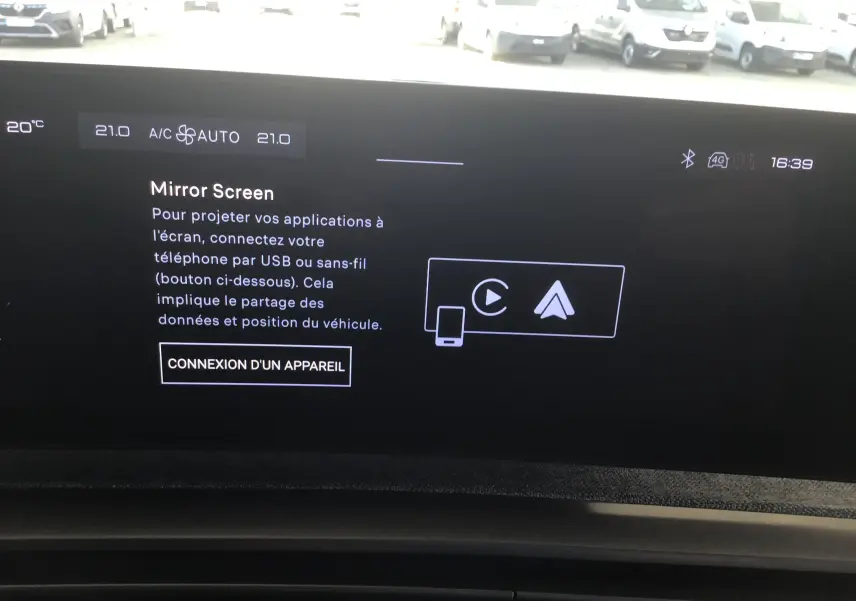 Gros plan sur le chargeur sans fil intégré au tableau de bord du Peugeot 3008 gris titane 2026.