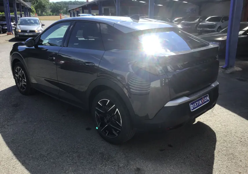 Peugeot 3008 gris titane vue 3/4 arrière droit sur parking, avec jantes noires et vitres teintées.