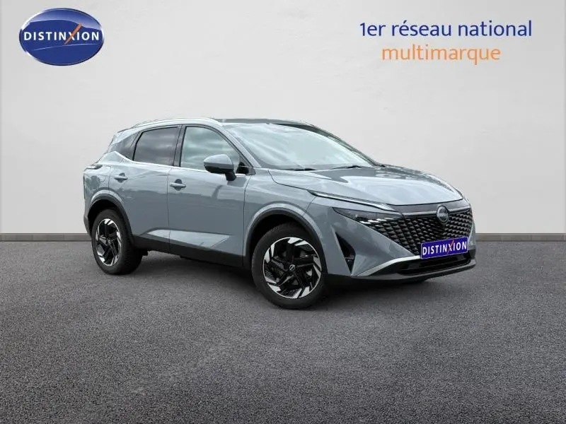 Nissan Qashqai 2025 gris Argile en 3/4 avant droit, avec calandre noire et jantes alu bicolores.
