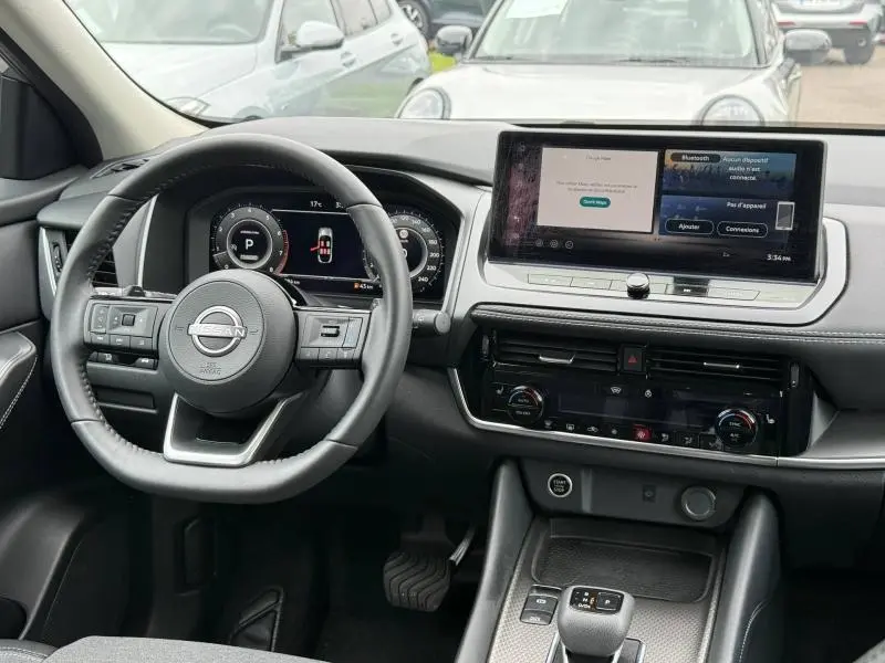 Vue intérieure du tableau de bord et volant cuir multifonction du Nissan Qashqai 2025, finition N-Connecta en gris Argile.