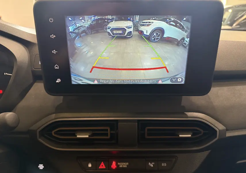 Écran central du Dacia Jogger Hybrid 140 Extreme montrant la caméra de recul avec vue sur un parking intérieur.