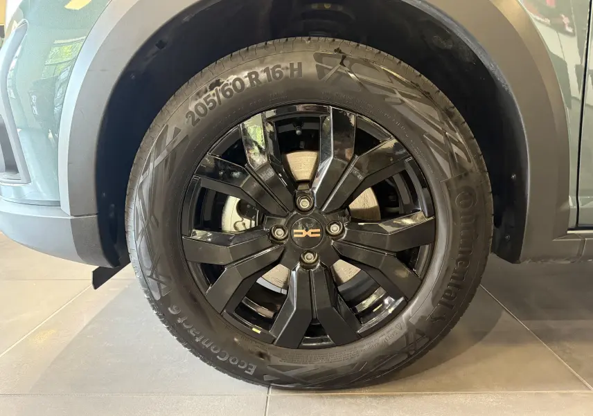 Gros plan sur la roue avant gauche noire brillante du Dacia Jogger Hybrid 140 Extreme Vert Cèdre 2023.