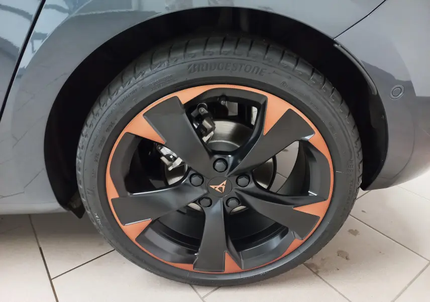 Gros plan sur la jante cuivrée et noire de 18 pouces d'une CUPRA Leon gris magnétique, côté arrière droit.