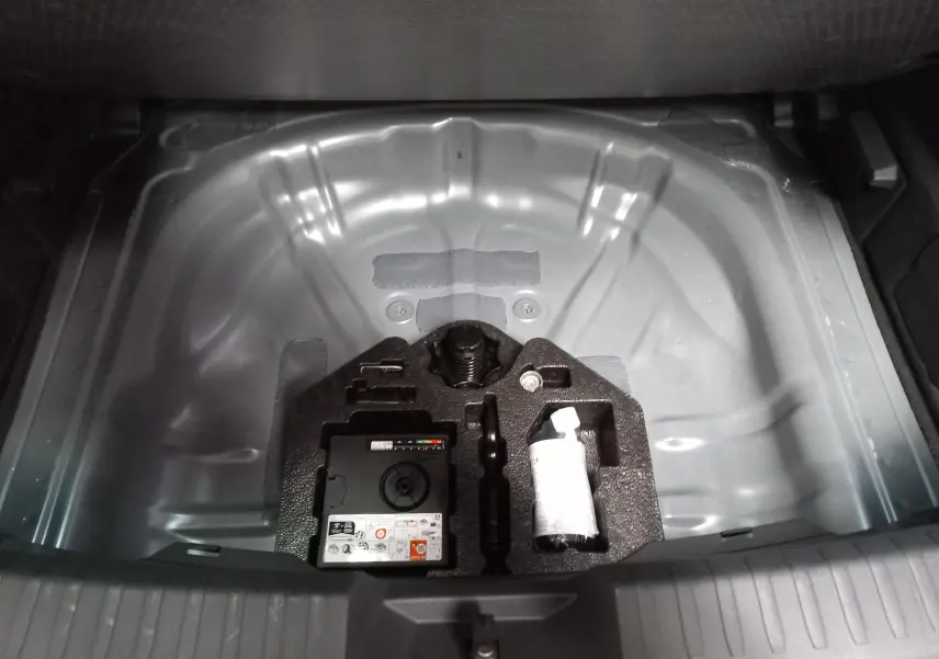 Coffre ouvert montrant le rangement sous plancher avec kit de réparation et compresseur sur CUPRA Leon 2025.