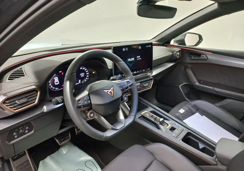 Vue intérieure côté conducteur du CUPRA Leon 2025 avec tableau de bord numérique et finitions cuivrées élégantes.