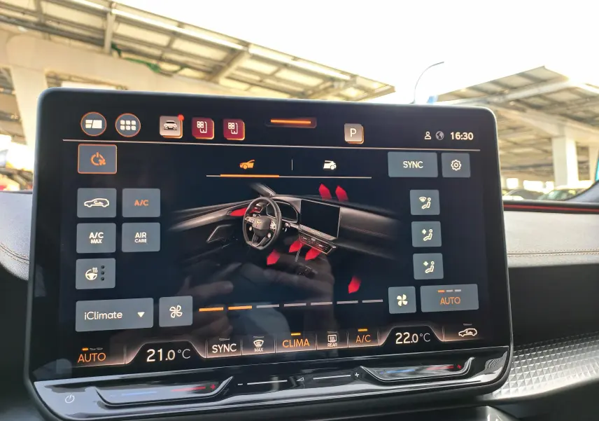 Écran tactile central affichant les commandes de climatisation du CUPRA Leon gris magnétique, intérieur moderne avec tableau de bord noir.