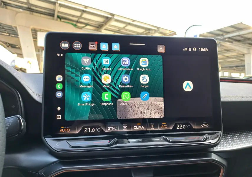 Écran tactile central de la CUPRA Leon 2025 affichant applications et commandes climatisation, intérieur moderne et soigné.