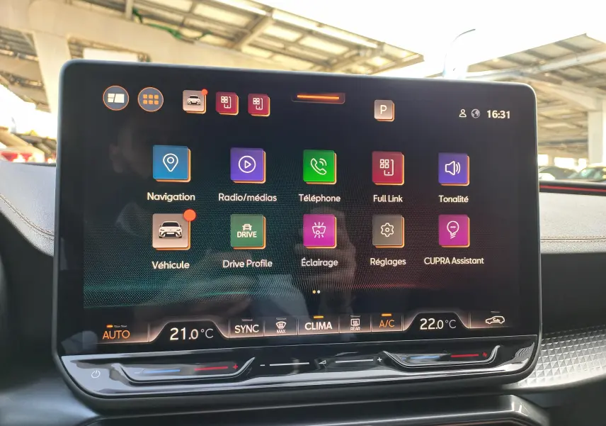 Écran tactile central du tableau de bord de la CUPRA Leon 2025 affichant les menus multimédia et réglages climatisation.