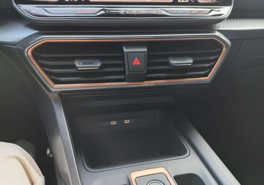 Détail de la console centrale du CUPRA Leon 2025 avec aérateurs et bordure cuivrée, prises USB-C et commandes climatisation.