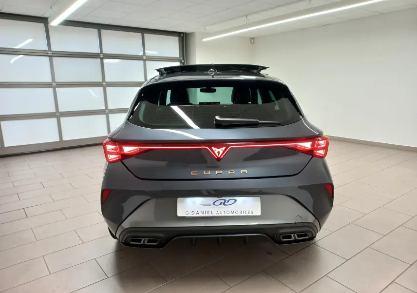 Vue arrière d'une CUPRA Leon gris magnétique avec feux LED reliés et double sortie d'échappement intégrée.