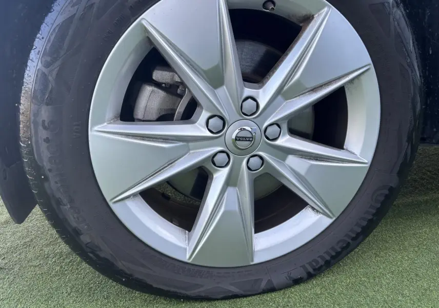 Gros plan sur la jante alliage 18 pouces argentée avec logo Volvo au centre du Volvo XC40 Fjord Blue.