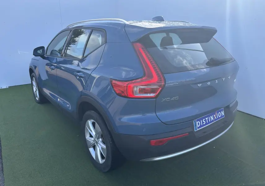 Vue 3/4 arrière droite d'un Volvo XC40 2024 Fjord Blue Metal avec feux arrière LED distinctifs et jantes alliage 18 pouces.