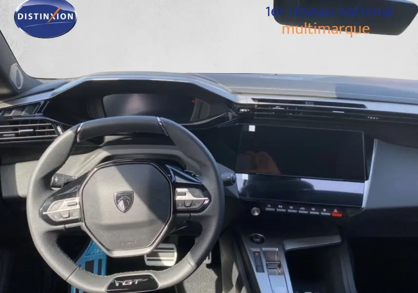Vue intérieure centrée sur le volant GT et le tableau de bord noir de la Peugeot 308 Hybrid 145ch 2026.
