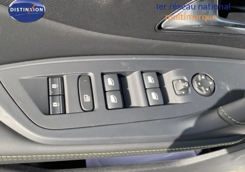 Vue rapprochée des commandes des vitres et rétroviseurs sur la porte côté gauche d’une Peugeot 308 Hybrid blanche.