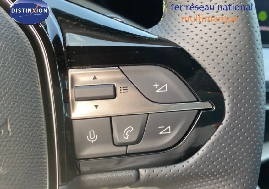 Gros plan sur les commandes de volume et téléphone au volant perforé de la Peugeot 308 Hybrid 145ch GT 2026.