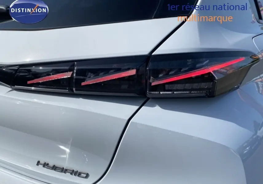 Gros plan sur le feu arrière droit et la partie arrière blanche métallisée d'une Peugeot 308 Hybrid 2026.