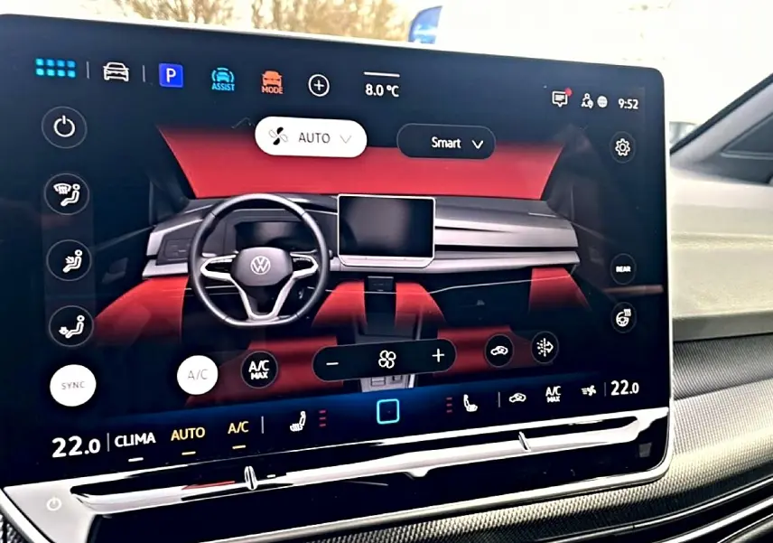 Écran tactile central affichant l'interface de climatisation de la Volkswagen Golf 2026 avec tableau de bord noir et rouge.