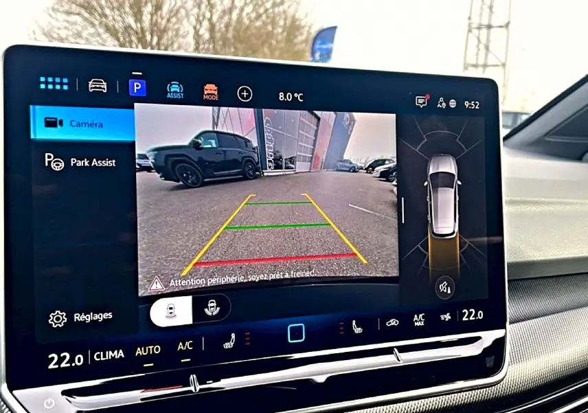 Écran central affichant la caméra de recul d'une Volkswagen Golf noire vue de l'arrière en stationnement.