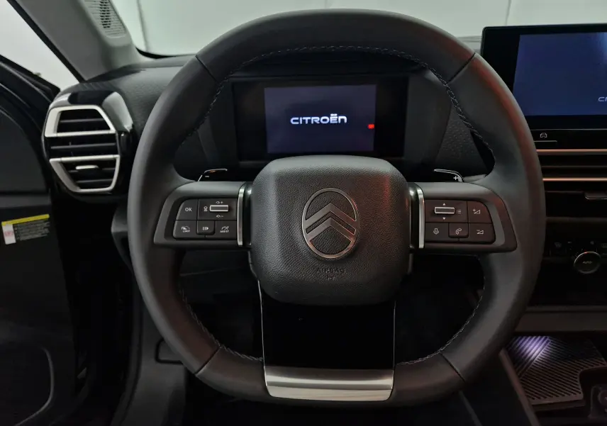 Volant en cuir noir de la Citroën C4 1.2 HYBRID 136 e-DSC6 MAX 2025 avec commandes intégrées et tableau de bord digital.
