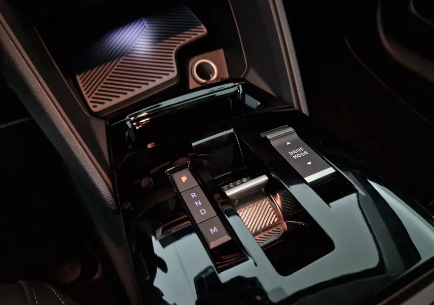 Gros plan sur la console centrale noire brillante de la Citroën C4 1.2 Hybrid 136 e-DSC6 MAX avec levier de vitesses et sélecteur Drive Mode.