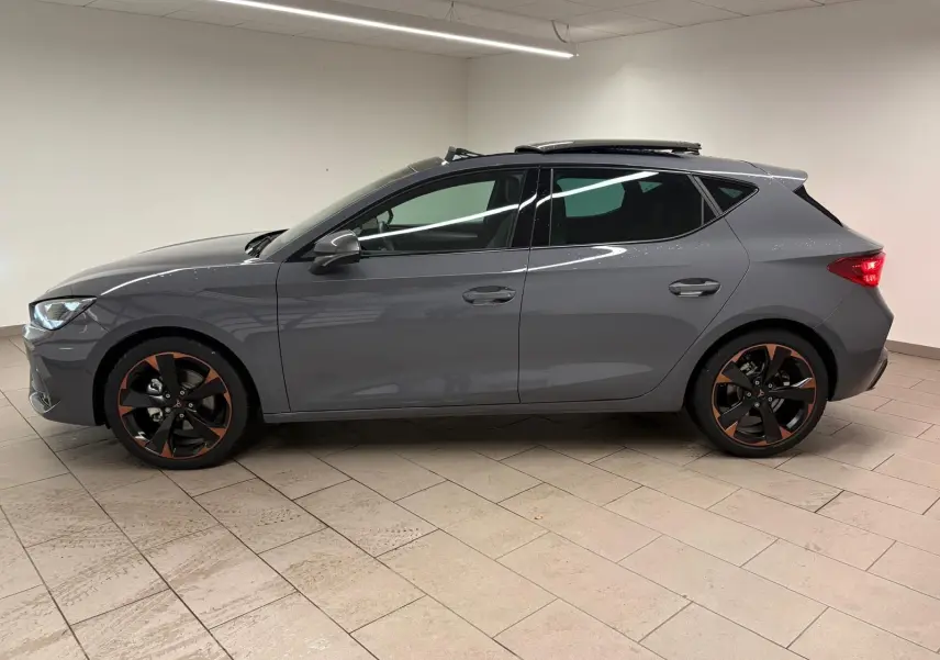 Vue latérale droite d'une CUPRA Leon gris Graphène avec toit ouvrant panoramique et jantes alliage 18'' cuivrées.