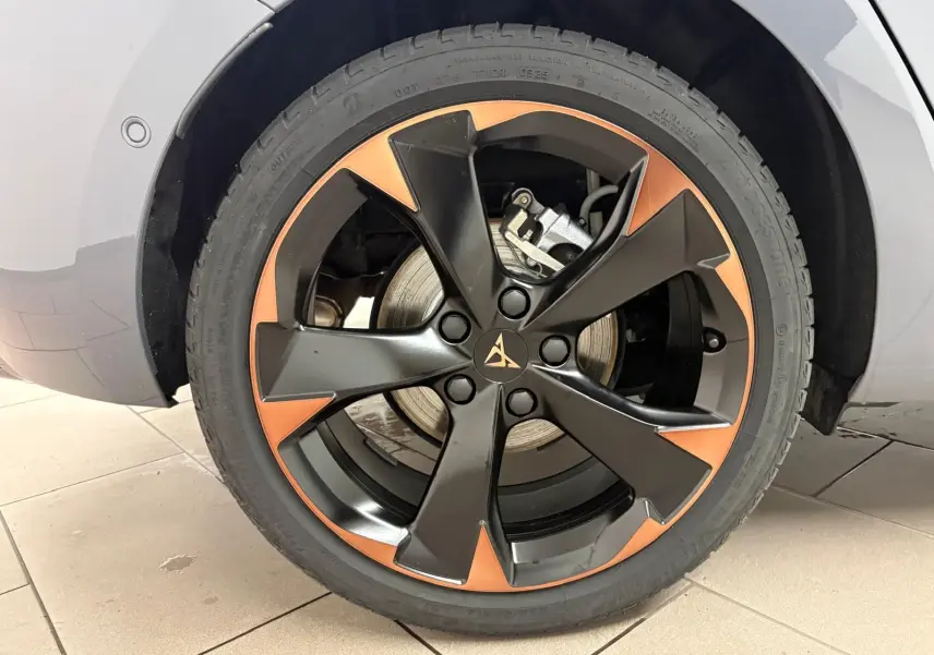 Gros plan sur la jante 18'' cuivrée et noire du côté arrière droit d'une CUPRA Leon gris Graphène.