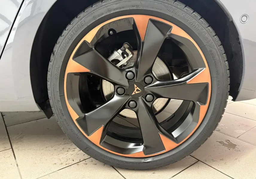 Gros plan sur la jante 18 pouces cuivrée et noire d'une CUPRA Leon gris Graphène, côté gauche avant.