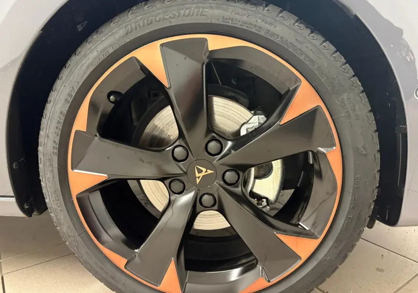 Gros plan sur la jante alliage 18'' cuivrée et noire du CUPRA Leon gris Graphène, mettant en valeur le logo central distinctif.