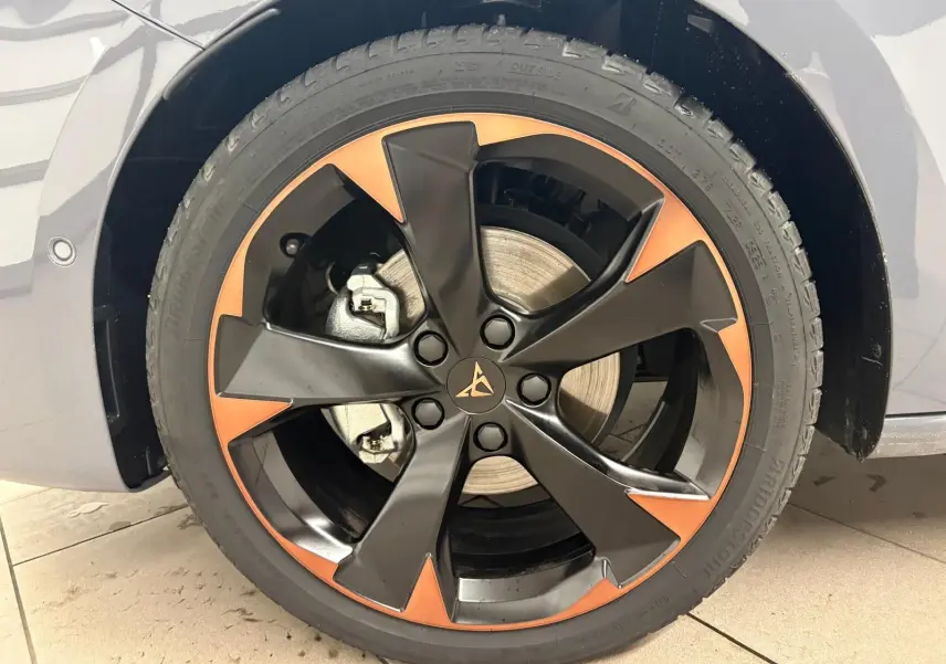 Gros plan sur la jante 18'' cuivrée et noire d'une CUPRA Leon Gris Graphène, avec frein visible derrière la roue.