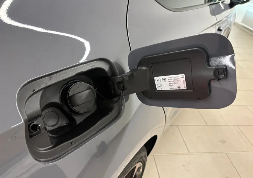 Gros plan sur la trappe à carburant côté gauche d'une CUPRA Leon gris Graphène avec jante alliage visible.