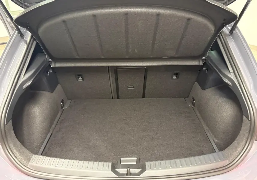 Coffre ouvert vu de l'arrière d'une CUPRA Leon gris Graphène, montrant un espace de chargement propre et spacieux.