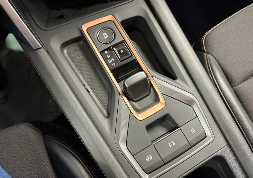 Gros plan sur la console centrale du CUPRA Leon 2025, avec levier de vitesses automatique et cadre cuivré.