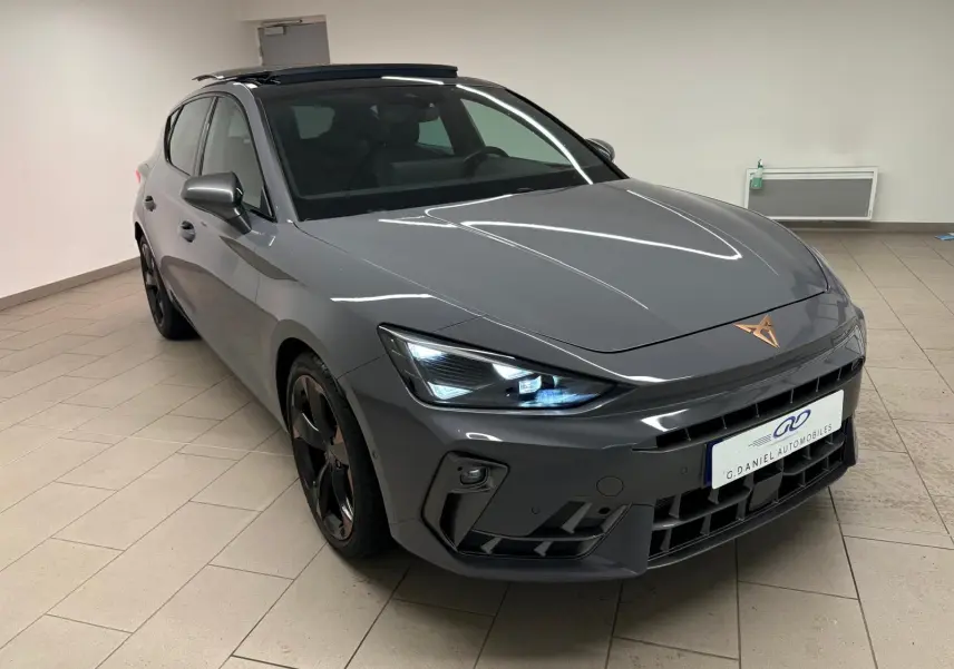 Vue 3/4 avant droit d'une CUPRA Leon gris Graphène avec toit ouvrant panoramique et jantes cuivrées en alliage 18 pouces.