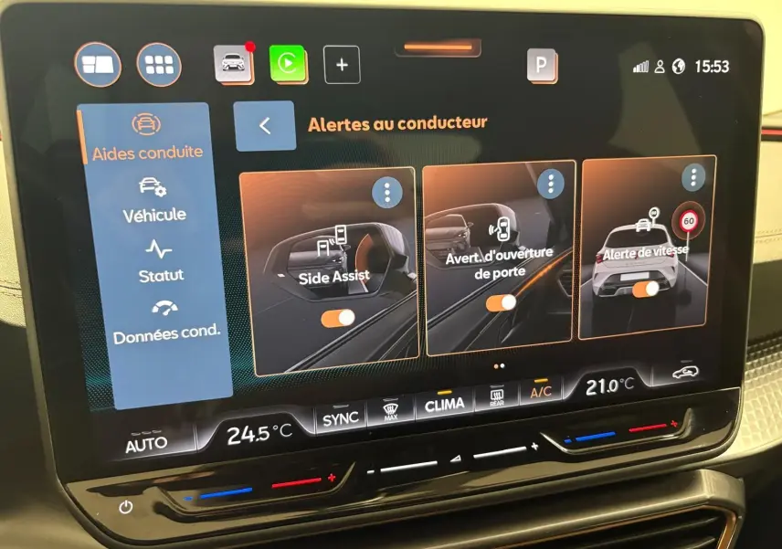 Écran tactile du tableau de bord de la CUPRA Leon 2025 affichant les alertes au conducteur et la climatisation.