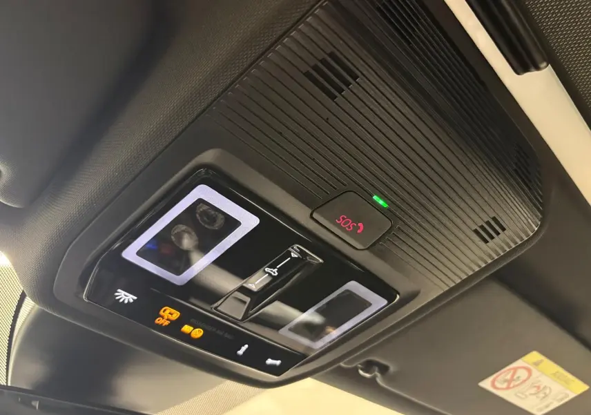 Vue en contre-plongée du panneau de commande intérieur noir avec bouton SOS et éclairage LED sur toit ouvrant d'une CUPRA Leon 2025.