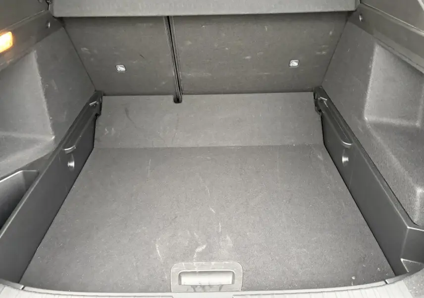 Coffre vide en vue plongeante d'un Renault Arkana 2025, intérieur tissu gris foncé, plancher plat amovible.