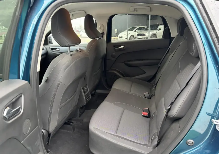 Vue intérieure arrière côté gauche du Renault Arkana bleu Zanzibar, montrant les sièges arrière en tissu gris et les portières ouvertes.