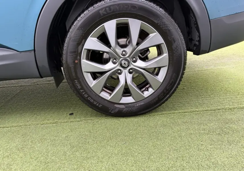 Gros plan sur la roue avant droite avec jante alliage grise du Renault Arkana Bleu Zanzibar 2025.