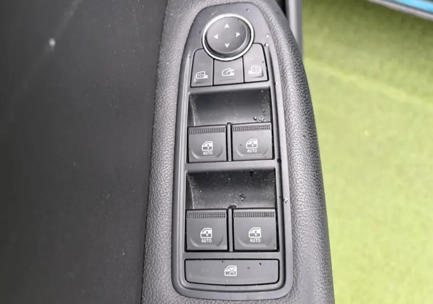 Gros plan sur les commandes des vitres électriques et rétroviseurs sur la porte côté gauche d'une Renault Arkana 2025.
