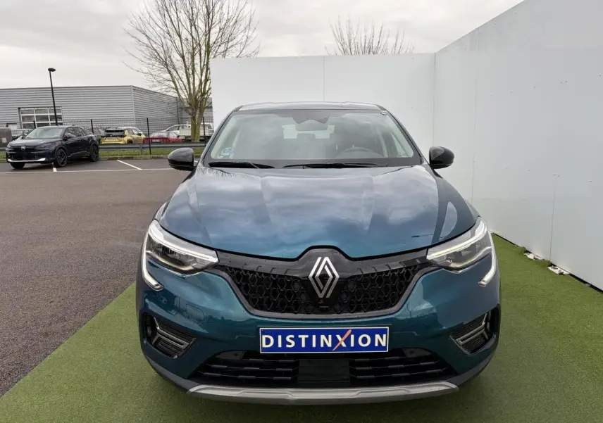 Vue avant d’un Renault Arkana bleu Zanzibar métallisé avec calandre noire et phares LED distinctifs.
