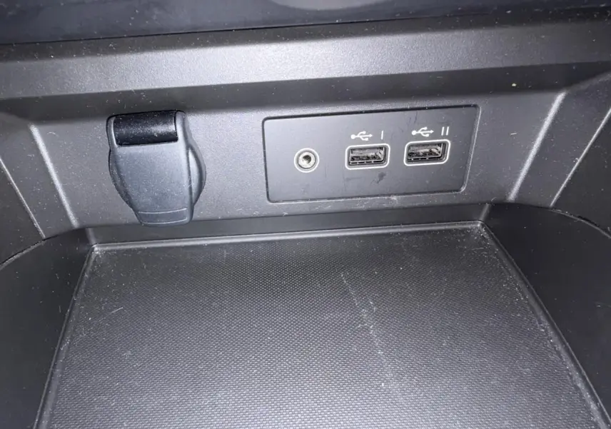 Gros plan sur la console centrale avec prises USB et prise jack du Renault Arkana 2025 en intérieur noir.