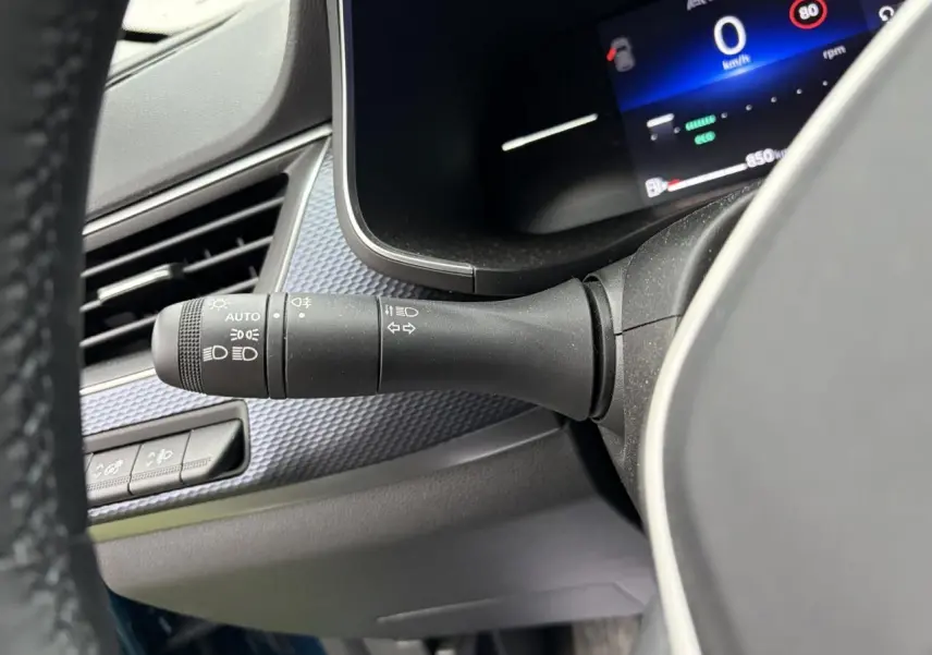 Gros plan sur la commande des feux et clignotants à gauche du volant du Renault Arkana bleu Zanzibar 2025.