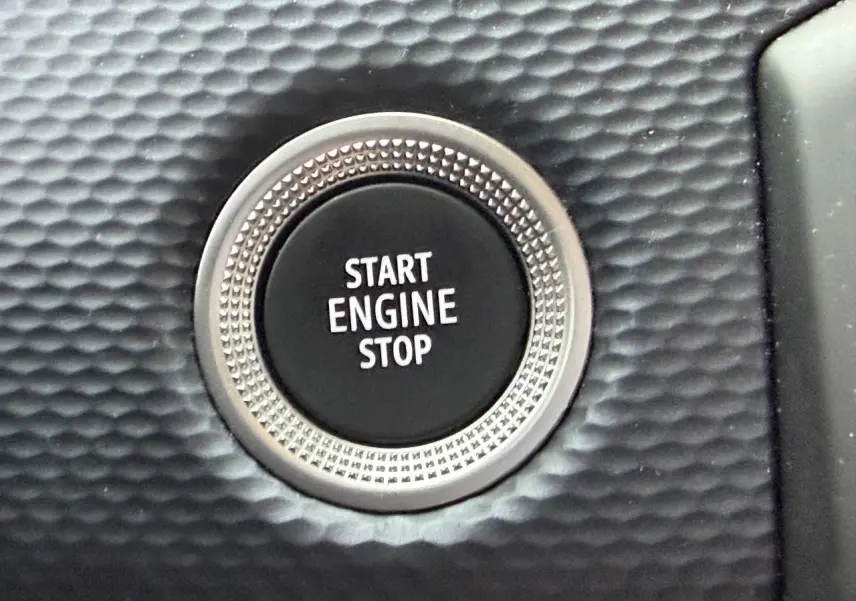 Gros plan sur le bouton Start Engine Stop entouré d’une finition texturée noire dans l’habitacle Renault Arkana Bleu Zanzibar.