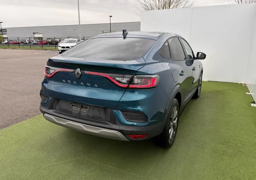 Vue 3/4 arrière droite d'une Renault Arkana bleu Zanzibar métal avec feux arrière LED et vitres surteintées.