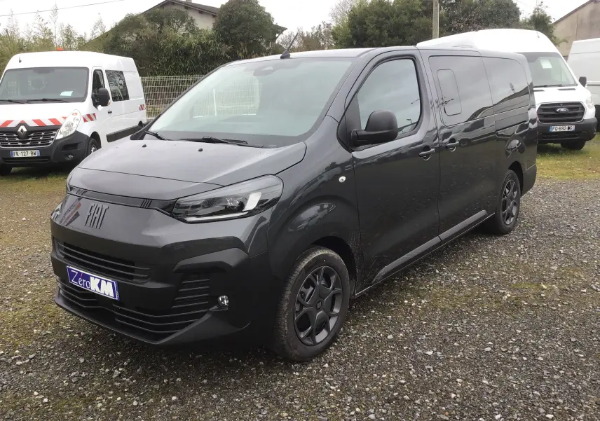 Vue 3/4 avant droit d’un FIAT Scudo Combi gris titane avec vitres latérales surteintées et jantes noires.