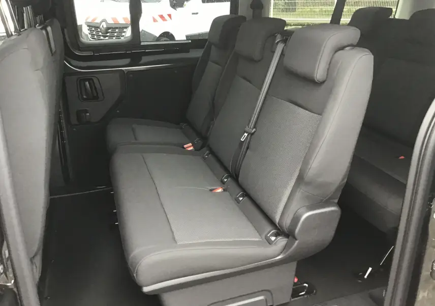 Vue intérieure côté droit montrant les sièges gris foncé du rang 2 du FIAT Scudo Combi XL 2026, avec vitres latérales coulissantes.