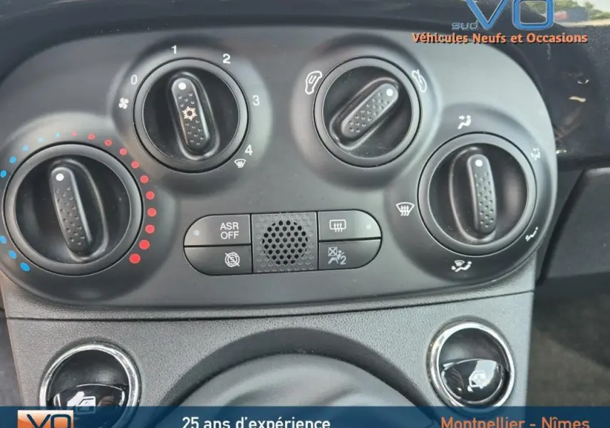 Gros plan sur les commandes de climatisation manuelle du tableau de bord d'une FIAT 500C noire 2024.