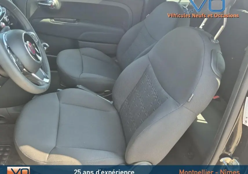 Vue intérieure côté conducteur de la FIAT 500C noire 2024, sièges tissu noir avec réglage hauteur et volant visible.