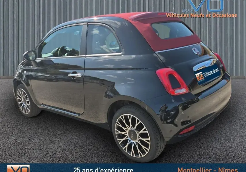 Fiat 500C noire vue 3/4 arrière droit avec toit rouge en toile et jantes alliage 15 pouces.