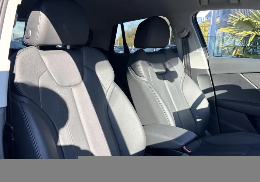 Vue intérieure des sièges avant en cuir gris de l'Audi Q2 35 TFSI S-Line, côté conducteur et passager.